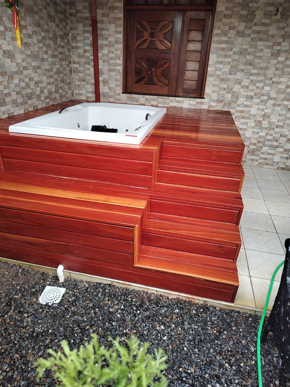 Deck e degraus em madeira ao redor de uma banheira de hidromassagem